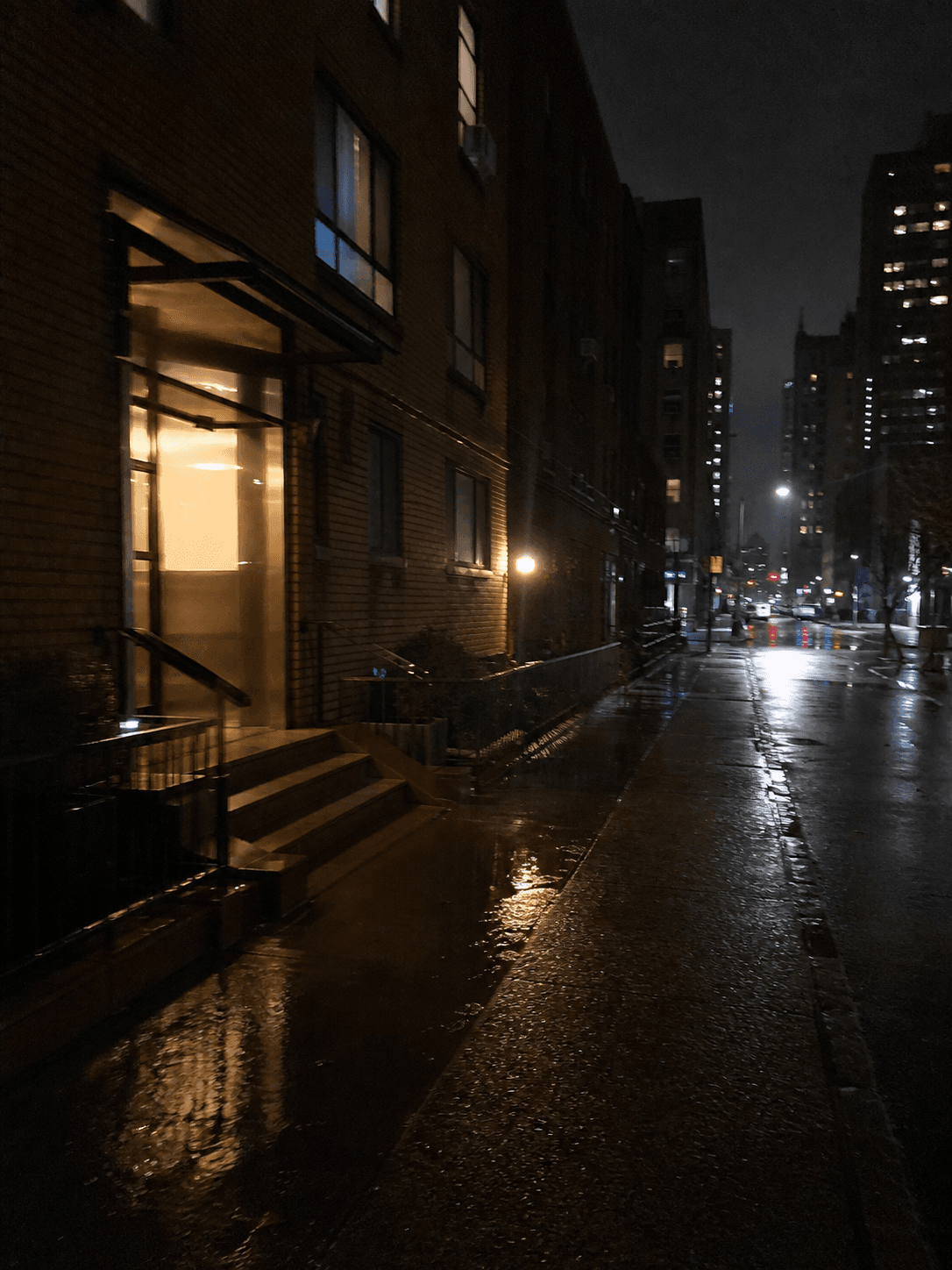 Yağmurdan sonra ıslak kaldırımlı loş ve boş bir gece sokağı