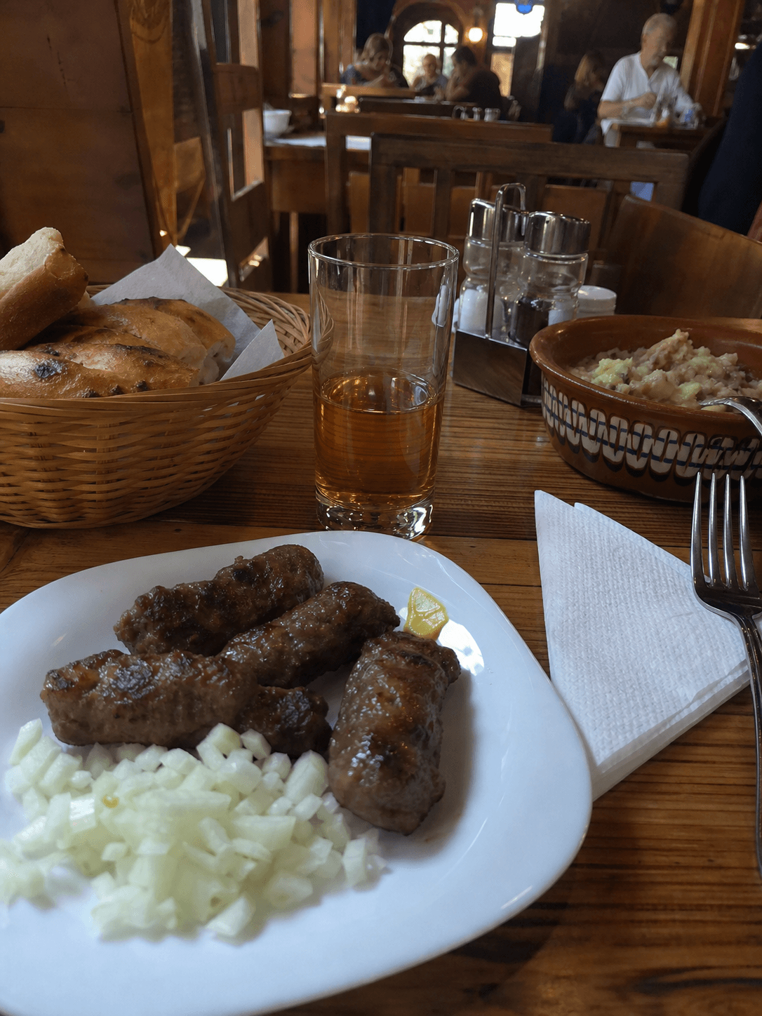 Tri Sesira tarzı geleneksel Belgrad restoranında ekmek, bardak ve tabakların olduğu masa detayı